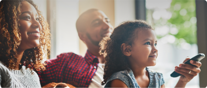 Famille noire regardant la télévision sur le canapé